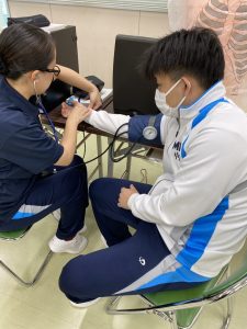 座って脈と血圧を測る様子